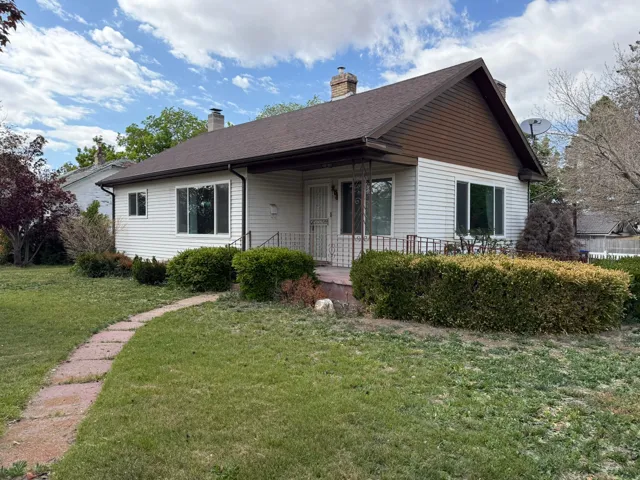 Front exterior featuring white siding and a brown shingle roof