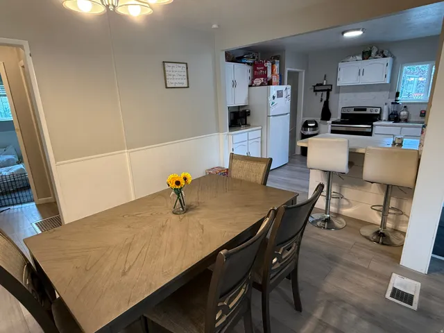 Dining area featuring wood-finish flooring and wainscoting