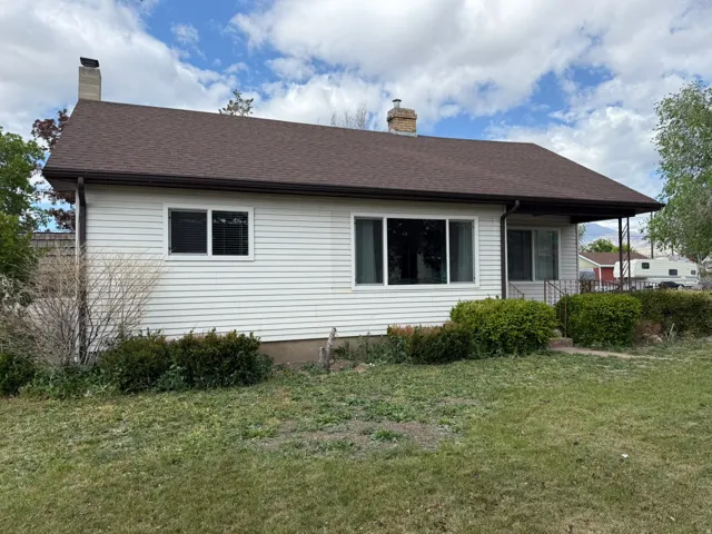 Ranch-style residence featuring white siding and a brown shingle roof