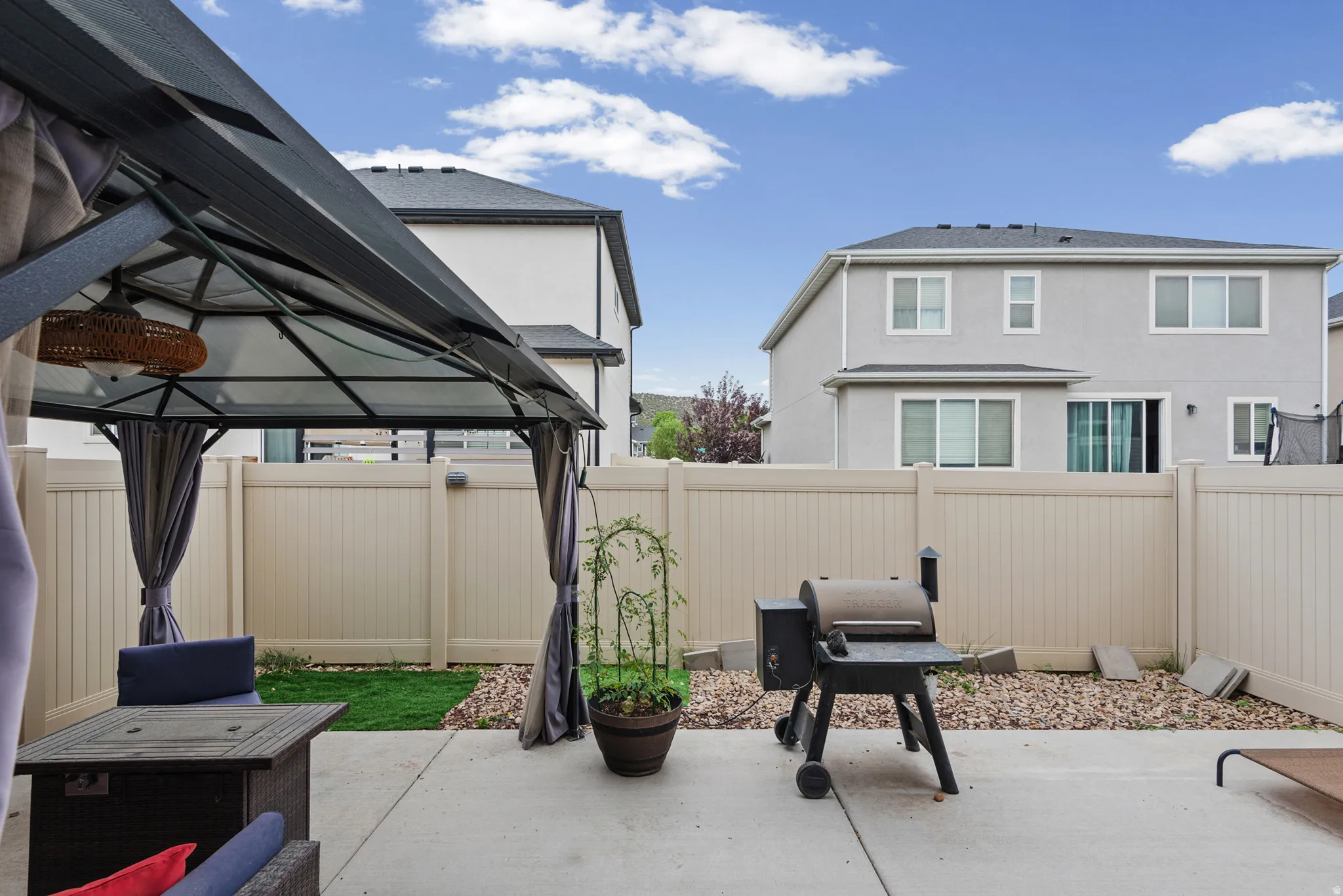 Expansive concrete patio area with a privacy fence