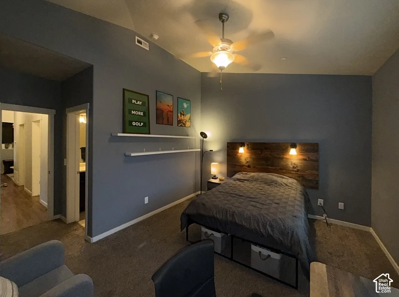 Vaulted ceilings featuring a central ceiling fan with integrated lighting and dual wall-mounted floating shelves