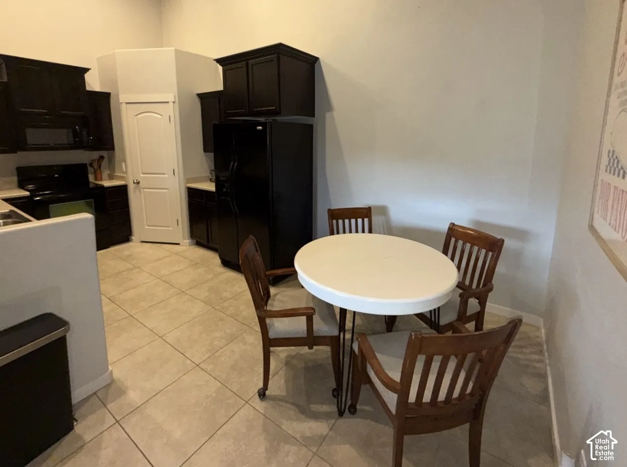 Kitchen featuring dark cabinetry, ceramic tile flooring, and built-in appliances