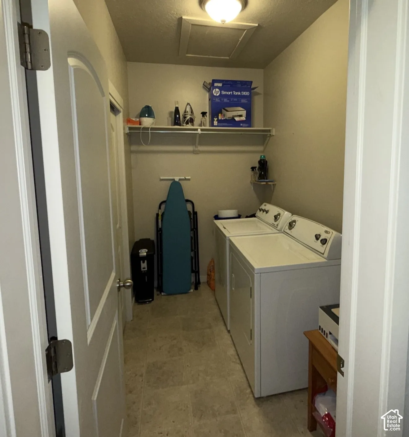 Utility room featuring tile flooring, ceiling-mounted light fixture, and built-in upper shelving
