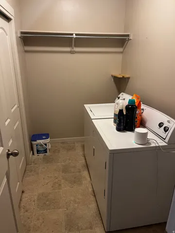 Dedicated laundry area featuring a tiled floor, overhead shelving, and a corner wall shelf