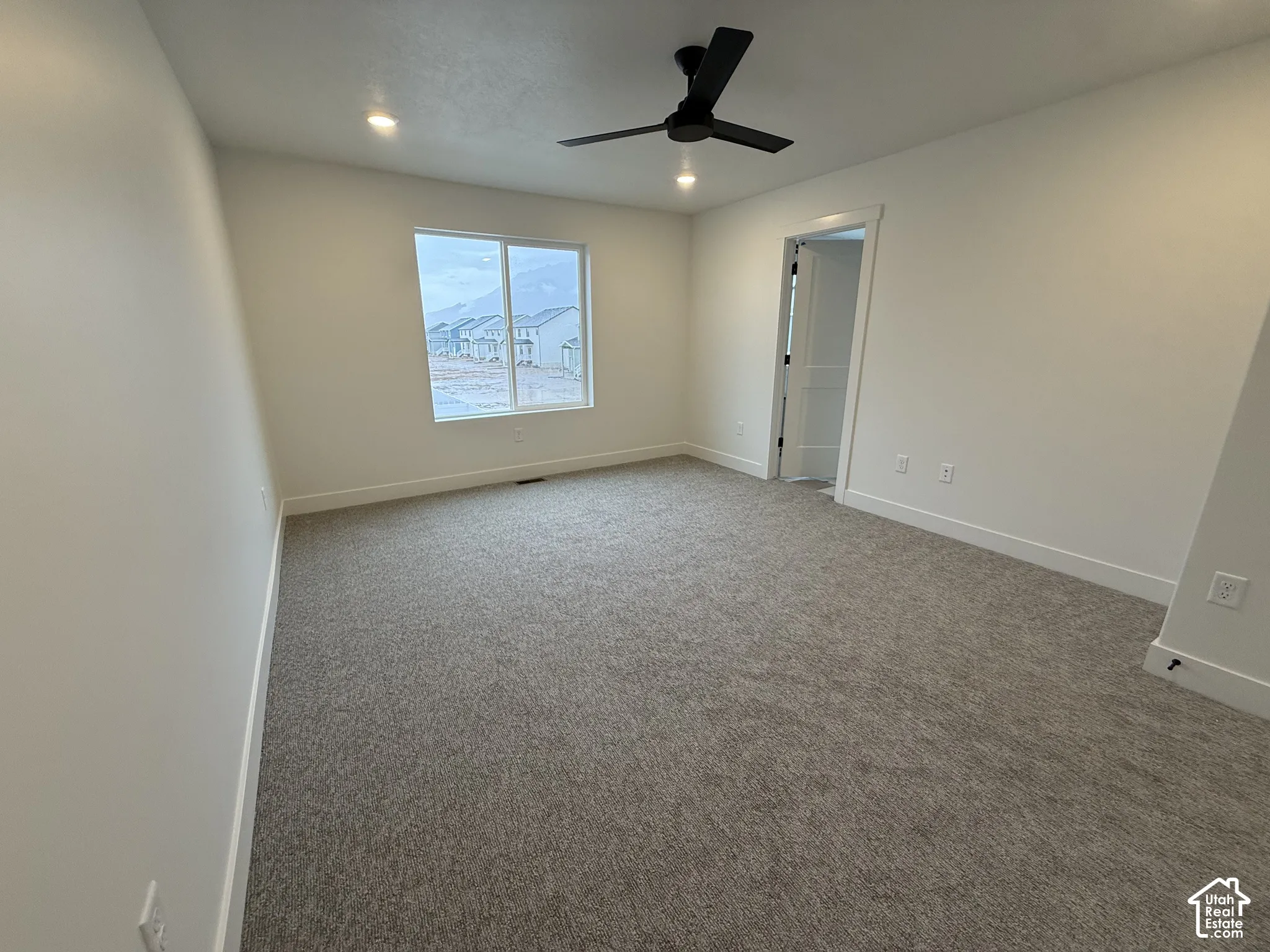 Carpeted room with recessed lighting, a modern ceiling fan, and a double-pane window