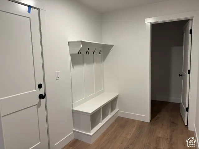 Built-in storage bench with cubbies, shaker-style doors with matte black hardware, and wood-finish flooring