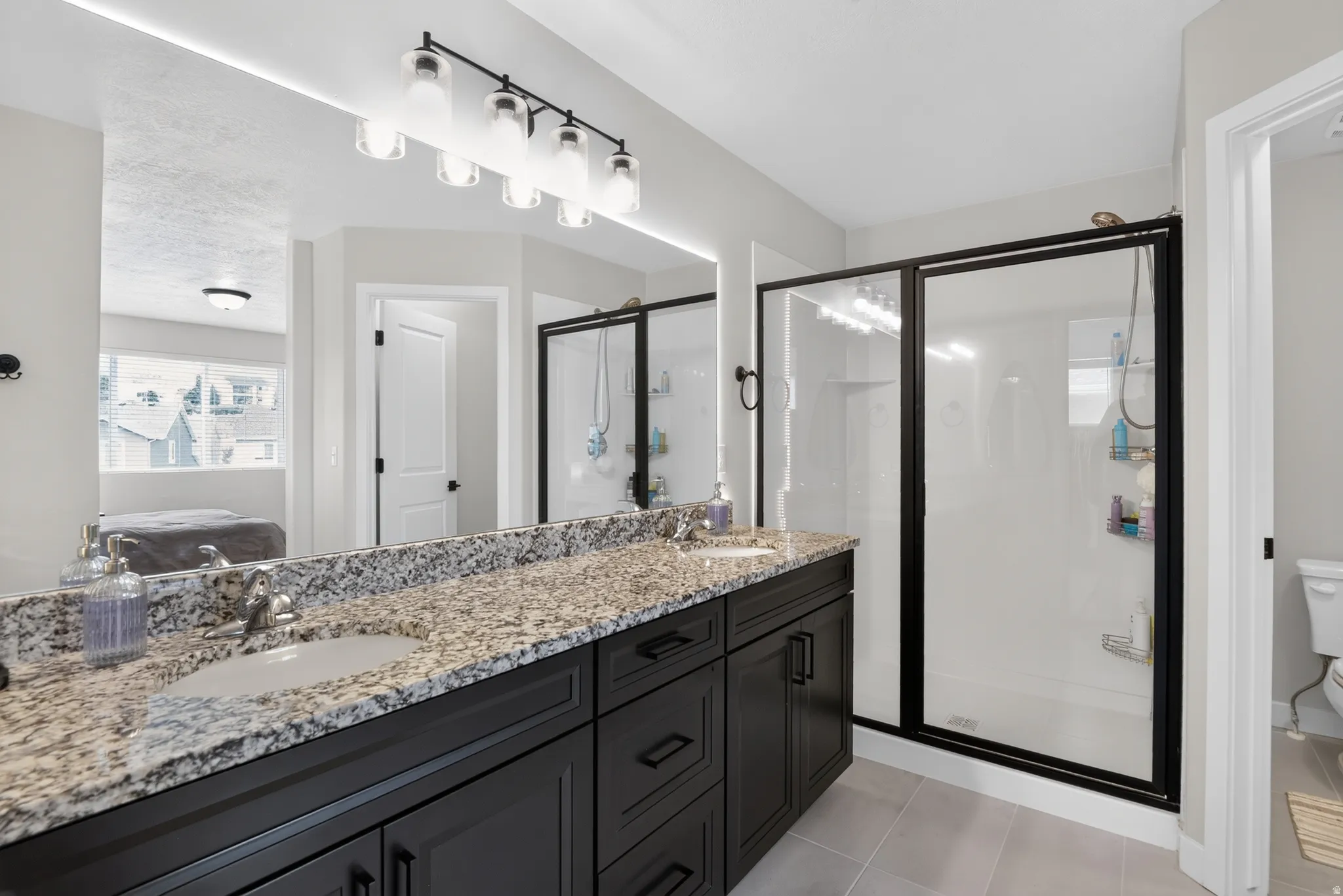 Double vanity with granite countertop and dark wood cabinetry