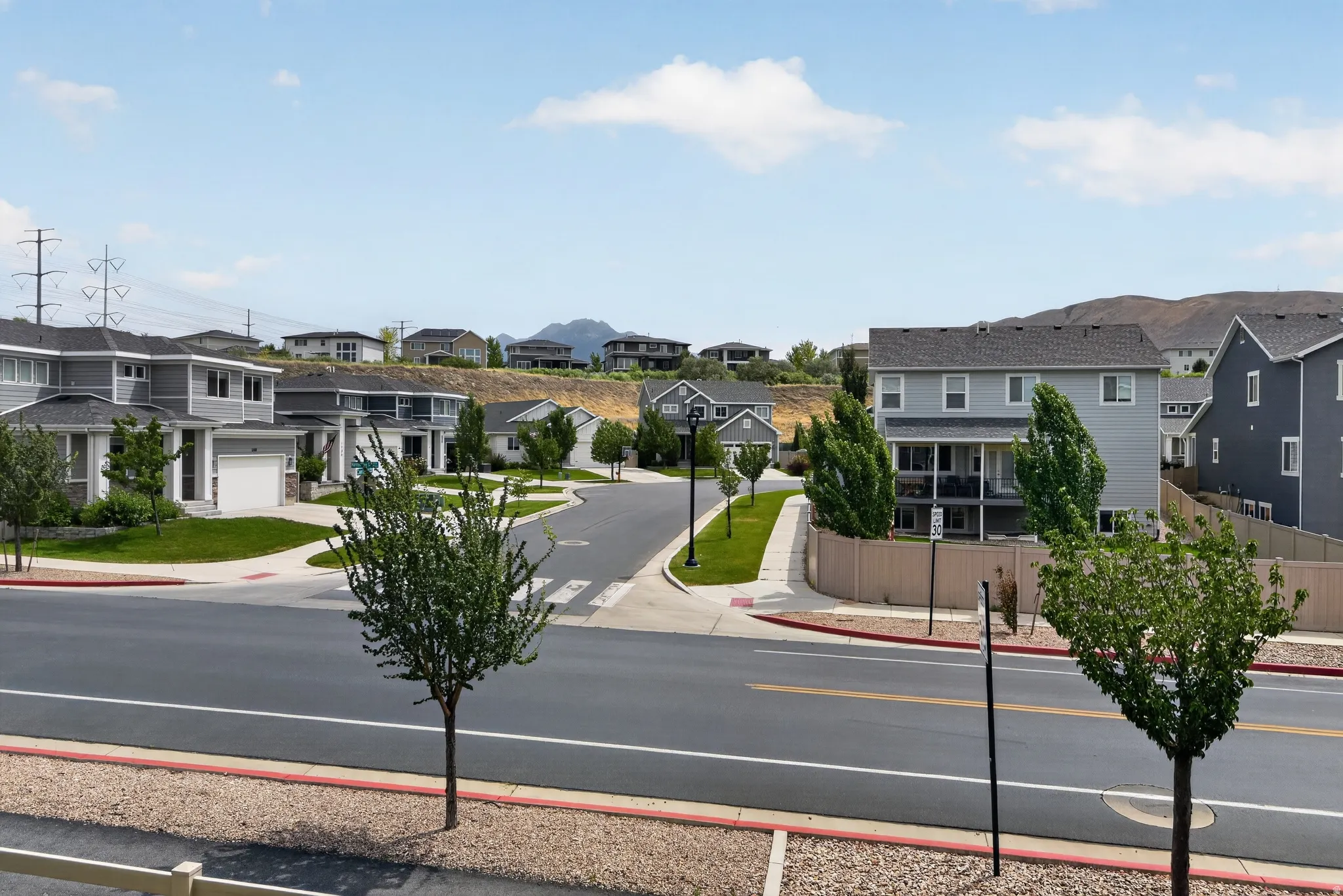 Residential street with modern homes featuring varied architectural styles and gray siding