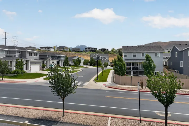 Residential street with modern homes featuring varied architectural styles and gray siding