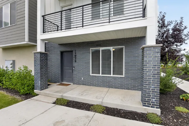 Contemporary facade featuring dark gray brick veneer, a coordinating front door, and white window frames