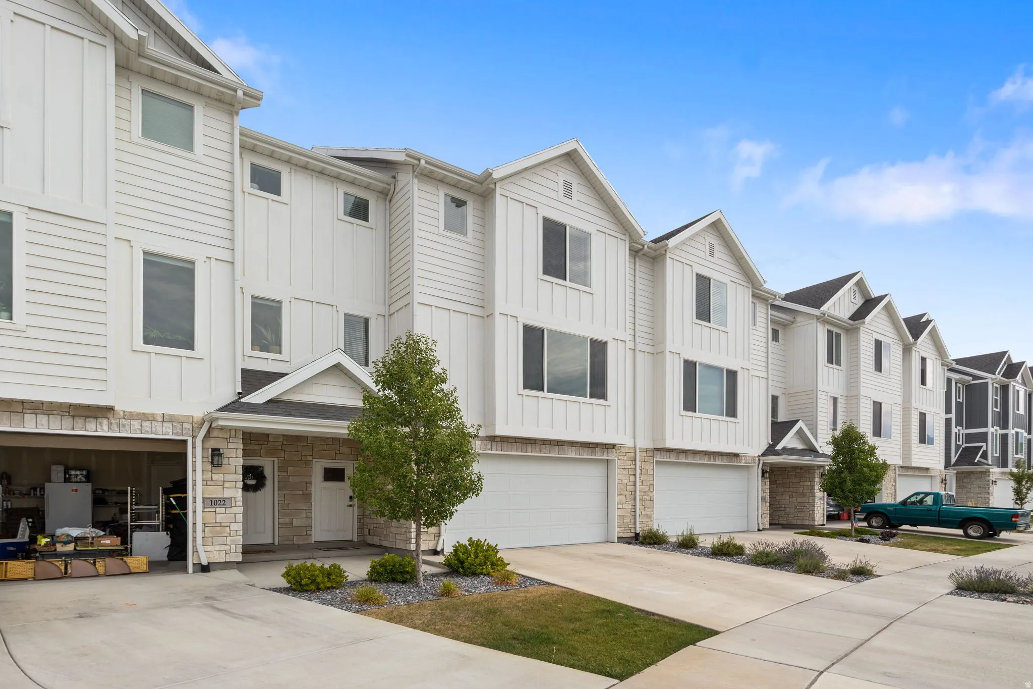 Modern townhome row featuring white horizontal siding and board and batten accents