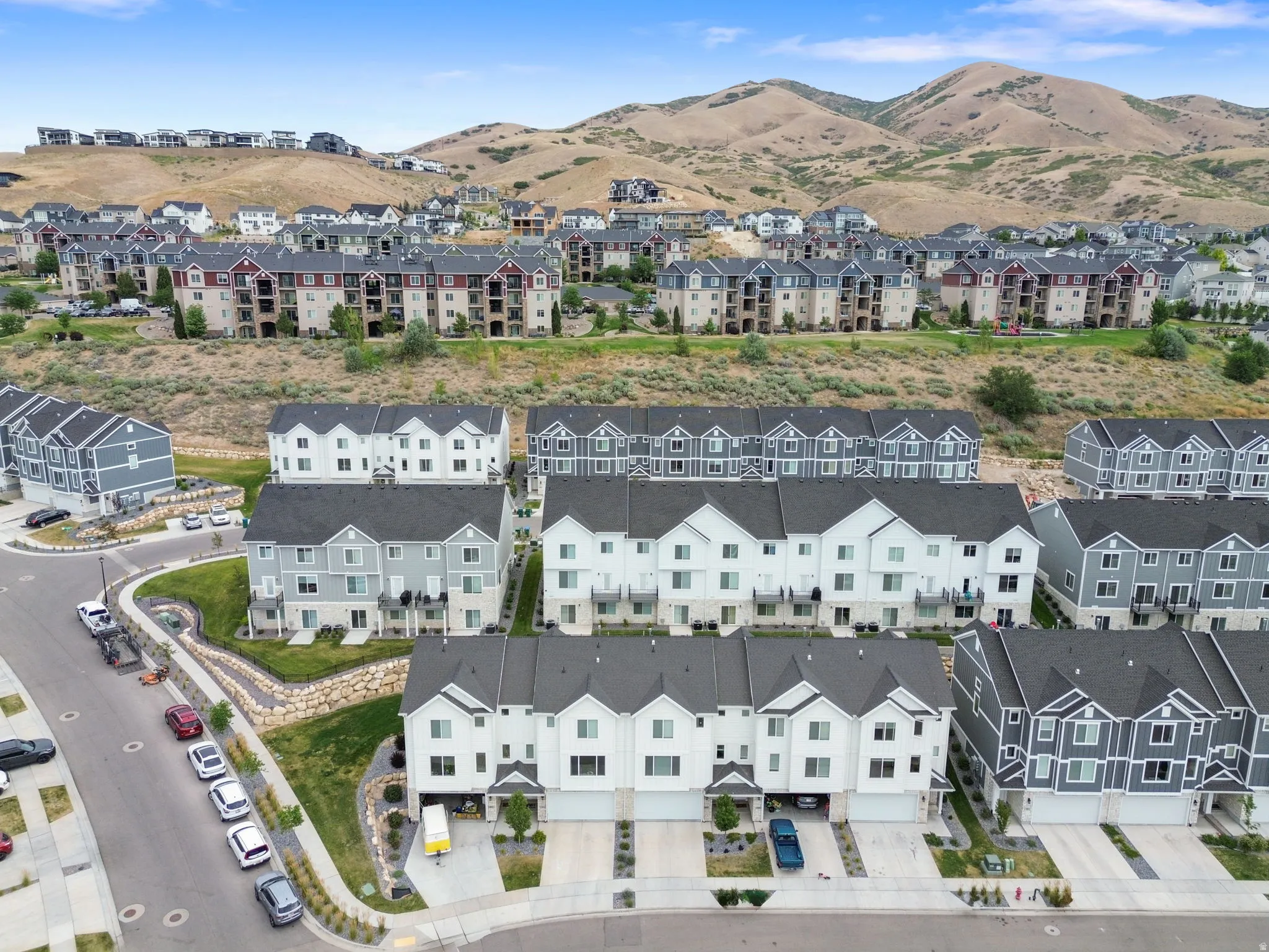 Aerial perspective showcasing a community of townhomes and multi-story buildings nestled into a hillside