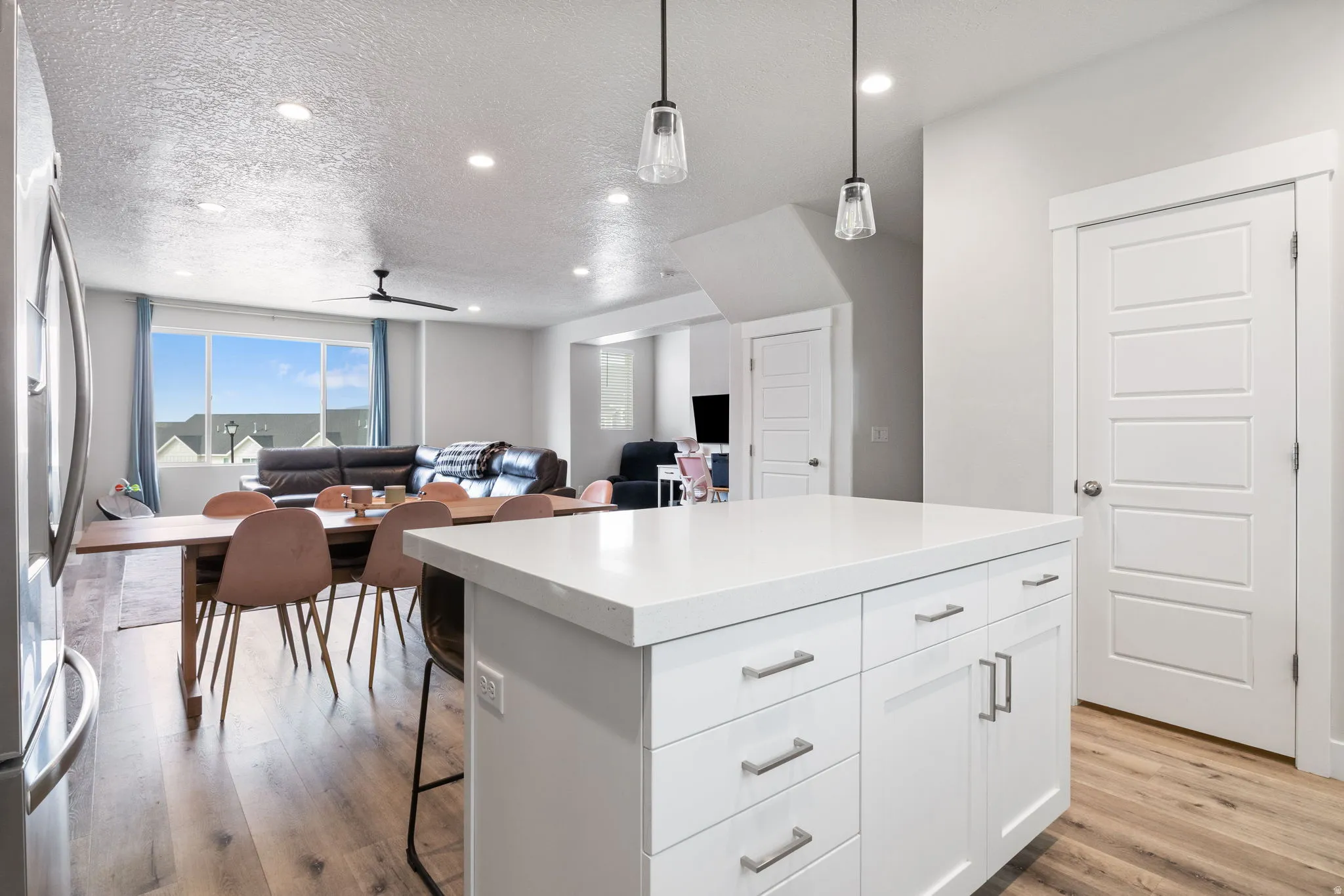 Kitchen island with a white countertop and base cabinetry, featuring brushed nickel hardware