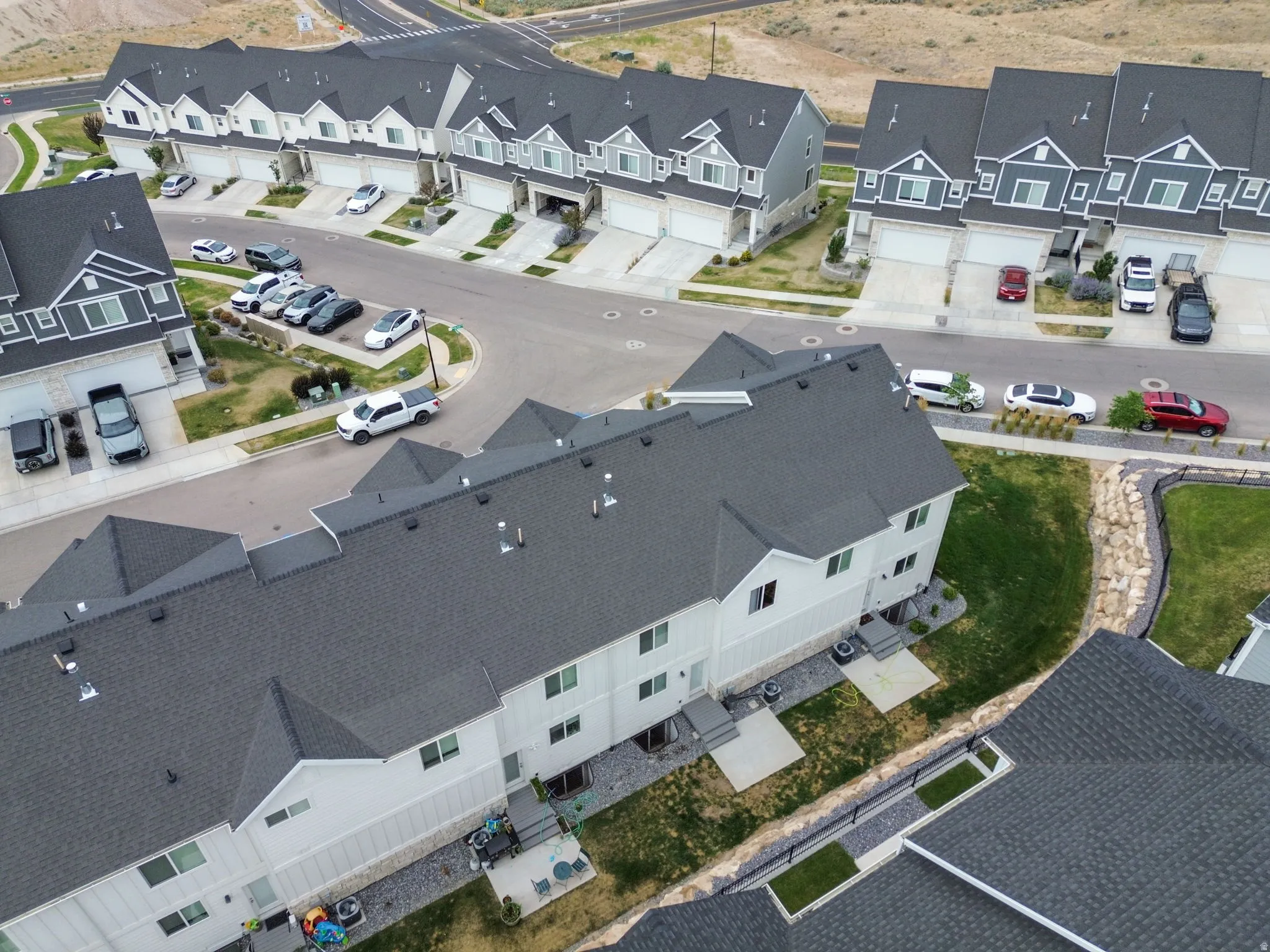 Modern residential development featuring multi-story townhomes with dark shingle roofs
