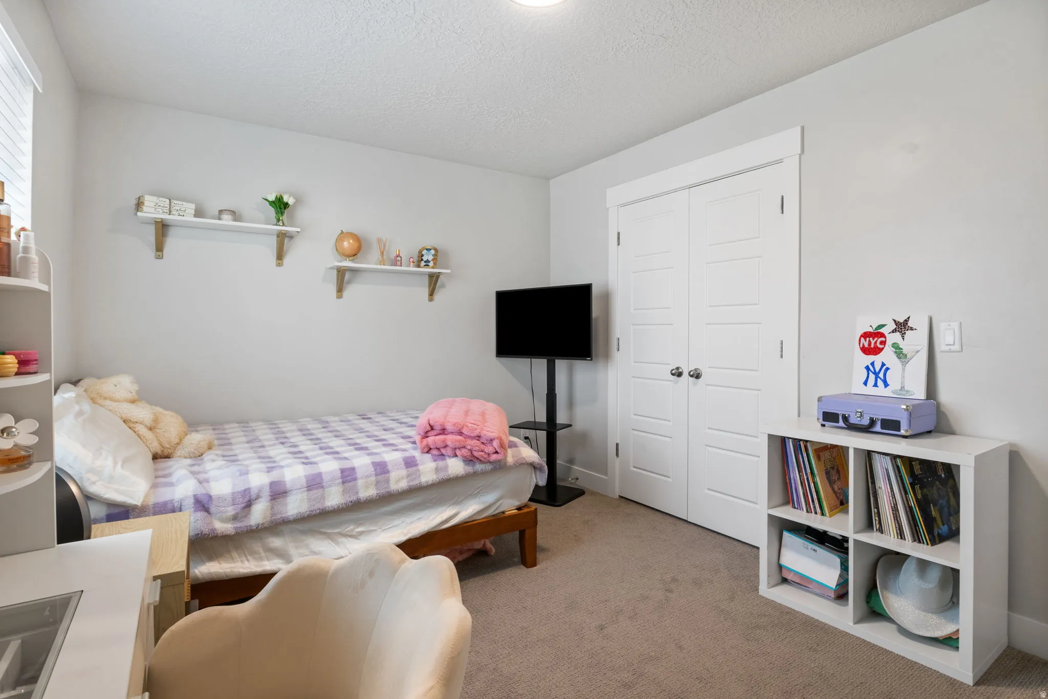 Interior room featuring neutral wall paint, carpet flooring, a built-in closet with double doors, and a window with blinds