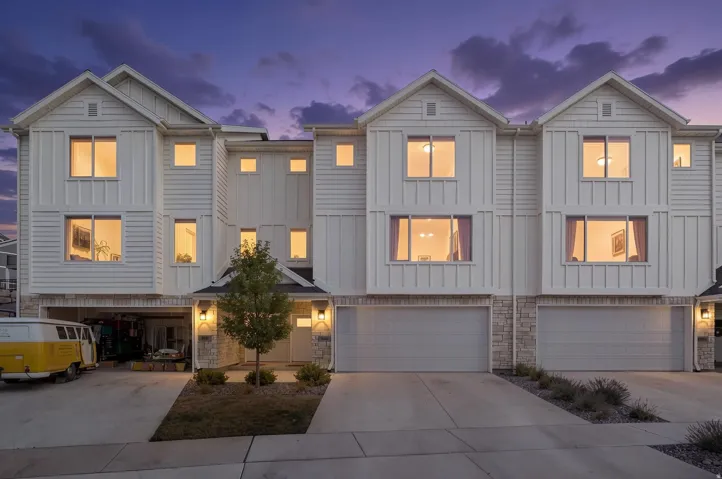 Contemporary townhome facade featuring white horizontal siding and vertical board-and-batten accents