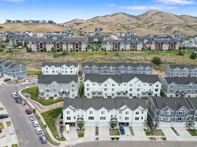 Aerial perspective showcasing a community of townhomes and multi-story buildings nestled into a hillside