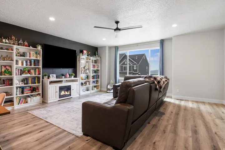 Spacious living area featuring wood-finish flooring, recessed lighting, and a modern ceiling fan