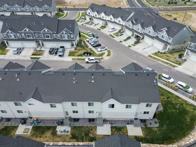Modern townhome-style residences featuring dark shingle roofs and light-toned siding