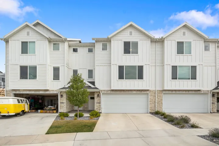 Modern townhome exterior featuring white horizontal siding and vertical board and batten accents