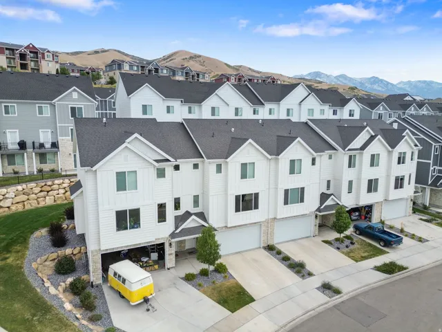 Modern townhome community featuring a white vertical siding and stone facade
