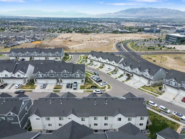 Aerial perspective showcasing new construction townhomes with dark shingled roofs and light-toned siding