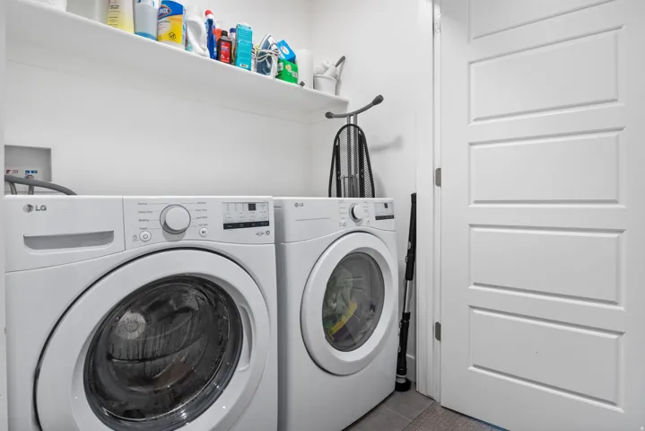 Dedicated laundry area featuring white walls, open shelving, and a paneled interior door