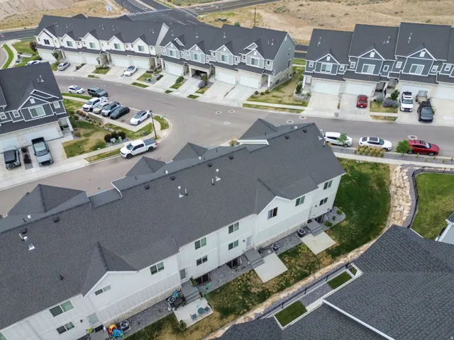 Modern residential development featuring multi-story townhomes with dark shingle roofs