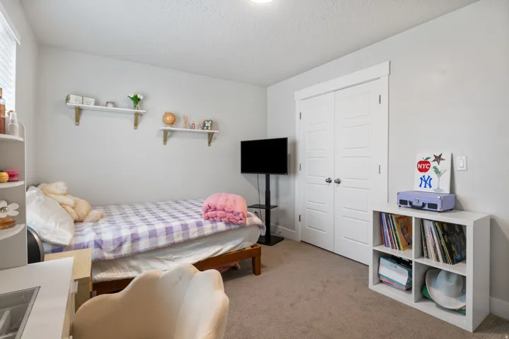 Interior room featuring neutral wall paint, carpet flooring, a built-in closet with double doors, and a window with blinds