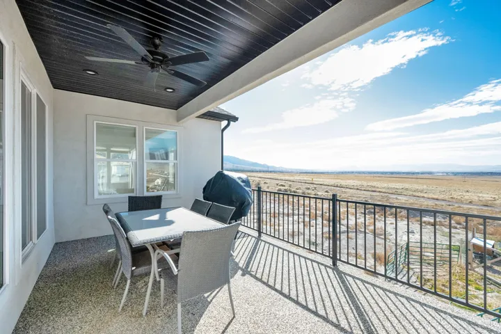 Covered patio featuring an exposed aggregate concrete floor, black slatted ceiling, and recessed lighting
