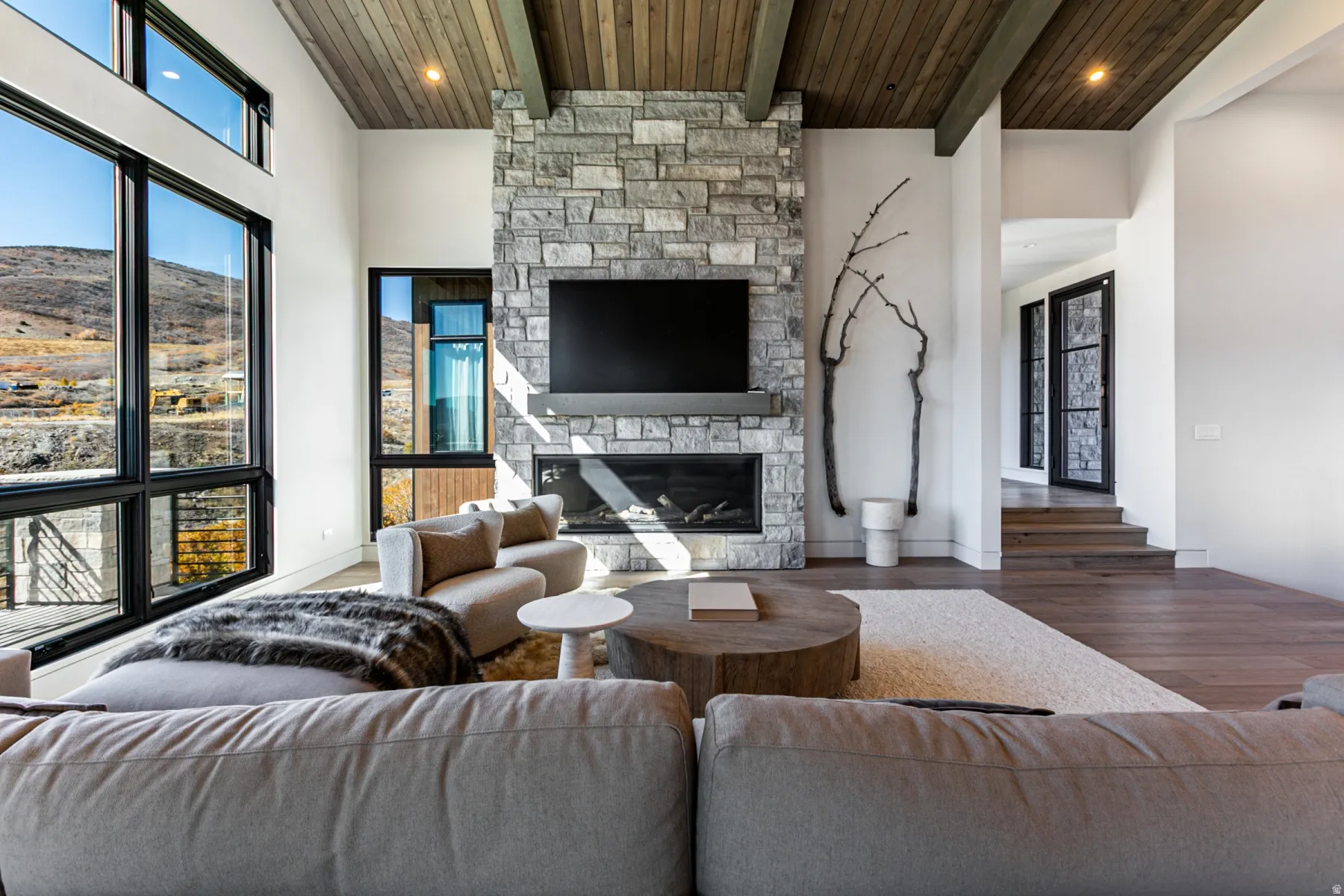 High ceilings featuring exposed wood beams and wood-finish paneling