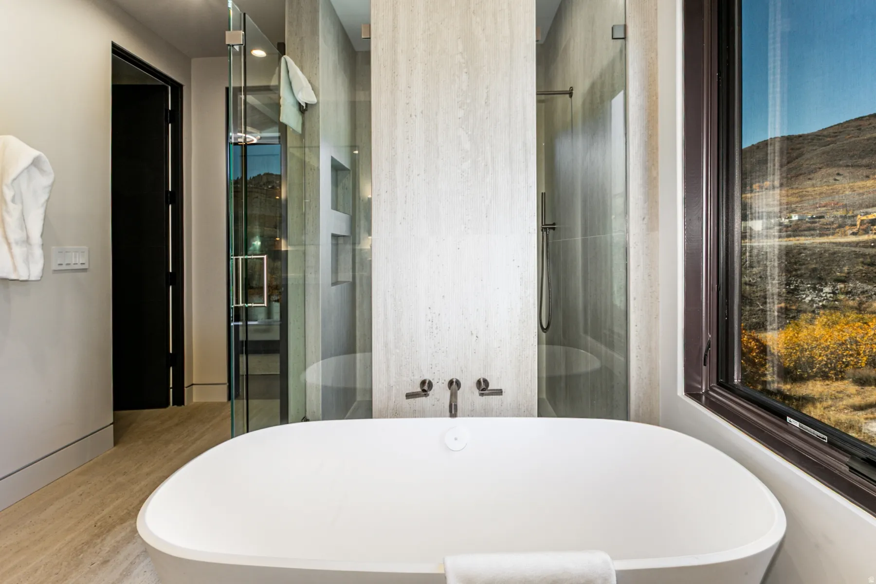 Freestanding soaking tub with wall-mounted fixtures