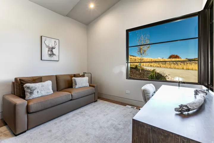 Accent wall with large black-framed window, offering extensive natural light and expansive outdoor scenery