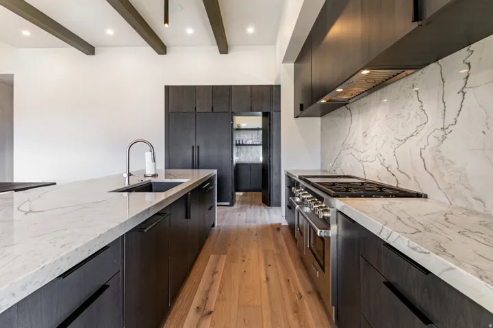 Gourmet kitchen with wood-finish flooring, exposed ceiling beams, and recessed lighting
