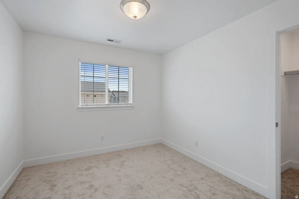 Neutral color palette throughout featuring light beige carpeting, white walls, and bright white trim