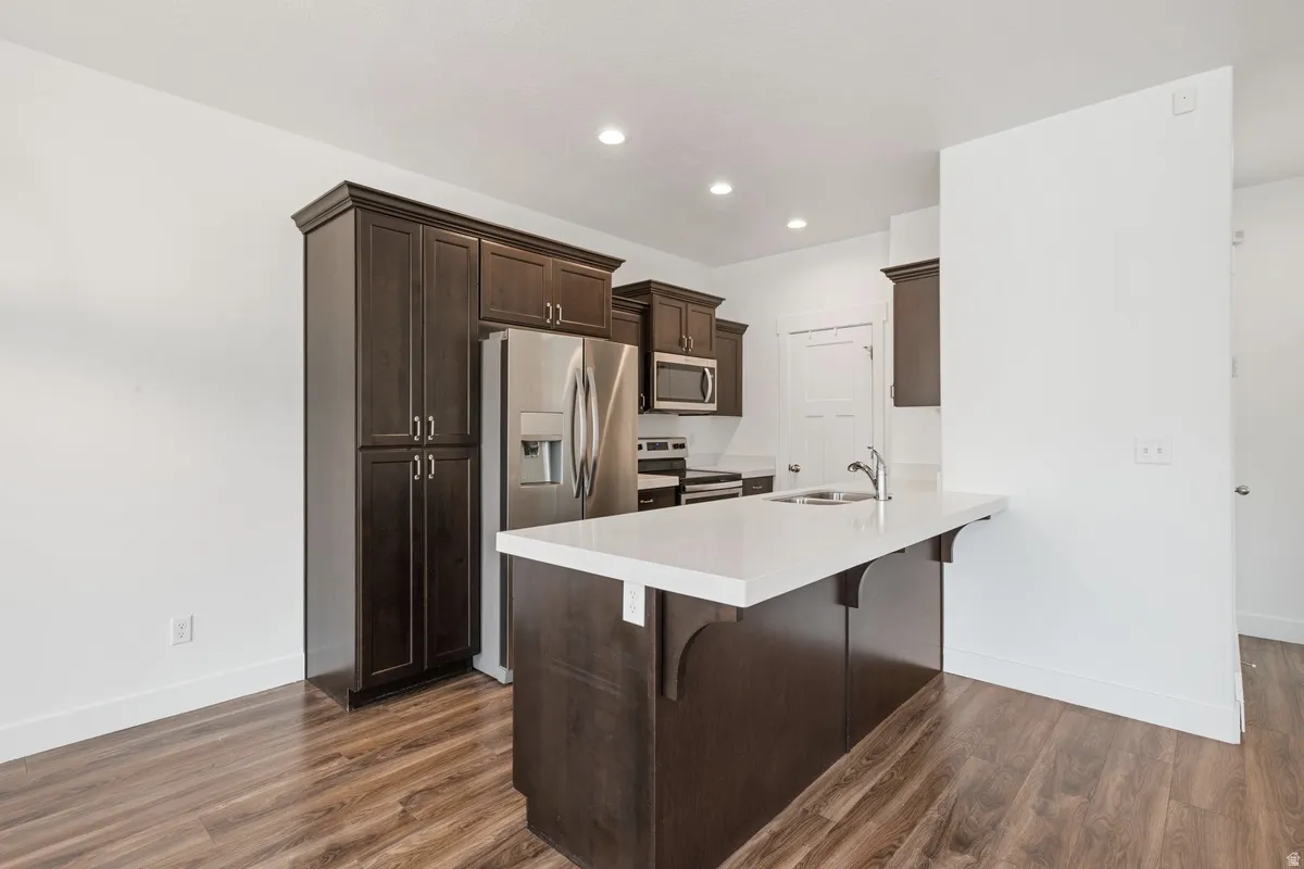 Modern kitchen featuring a central island with an integrated sink and white countertop