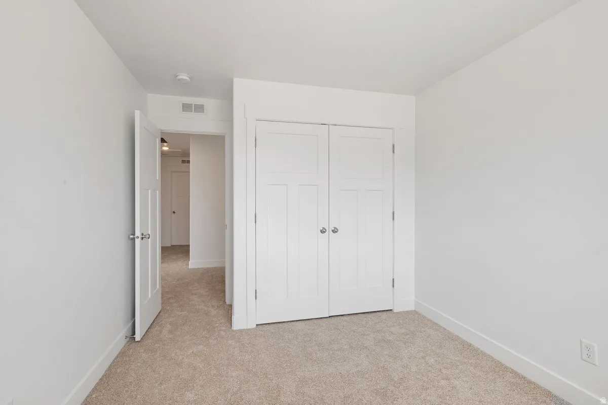 Neutral-toned carpeting paired with white walls, baseboards, and trim