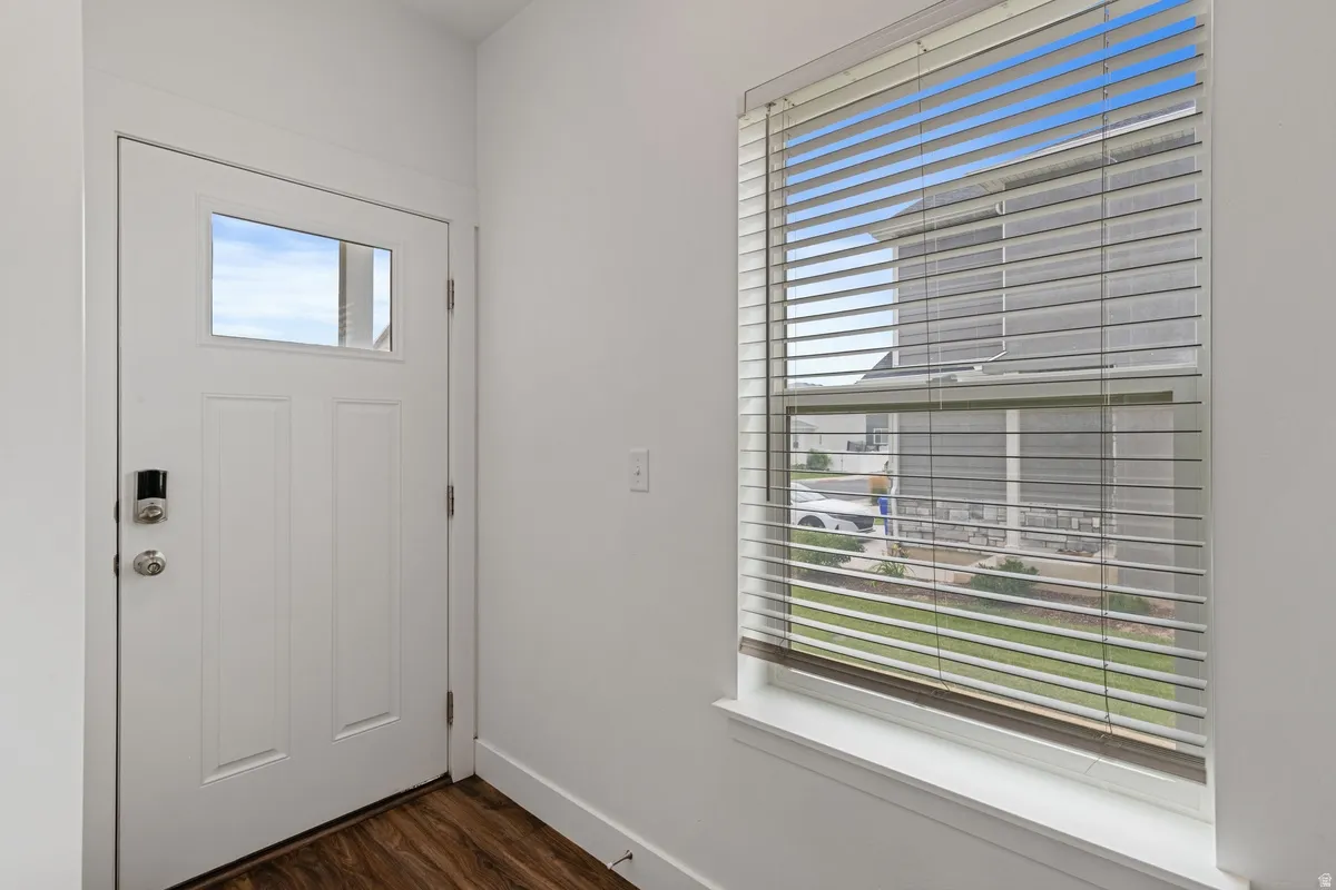 White entry door with a rectangular window pane and smart lock hardware