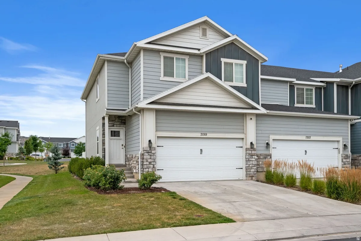 Contemporary townhome exterior featuring light blue siding with dark blue accents and white trim