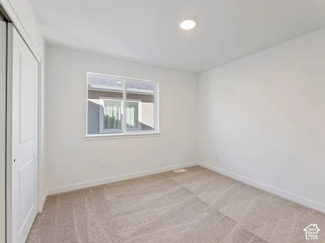 Neutral wall paint, recessed ceiling lighting, single window, carpet flooring, and bi-fold closet doors