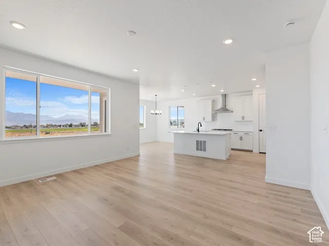 Open-concept living area featuring wood-finish flooring, recessed lighting, and expansive windows
