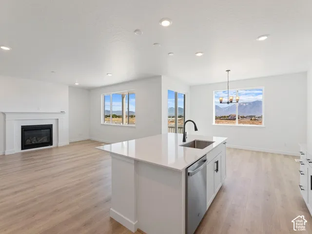 Open-concept living area featuring a fireplace, wood-finish flooring, recessed lighting, and large windows