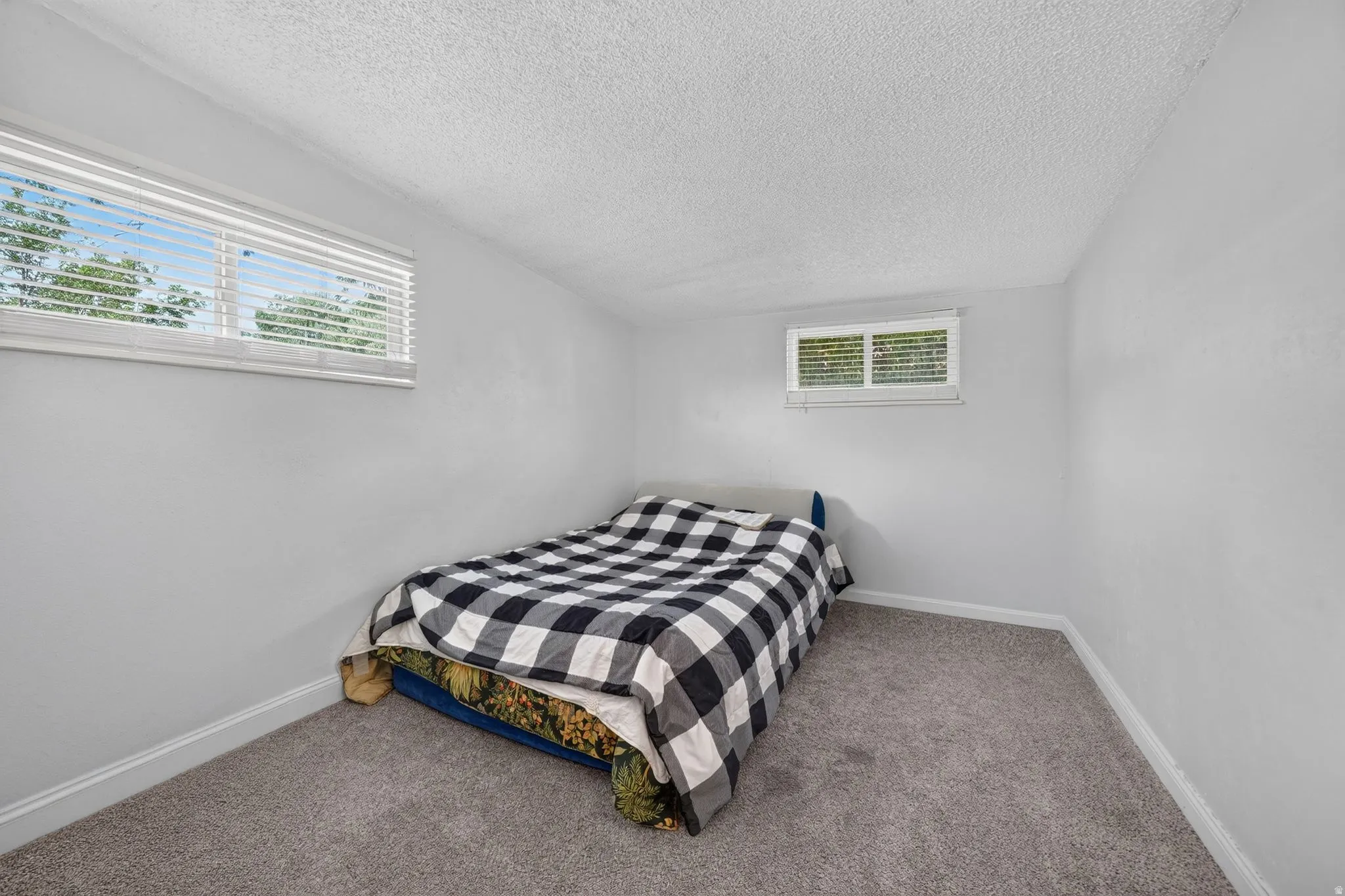 Room featuring light gray walls, gray carpeting, and white baseboards