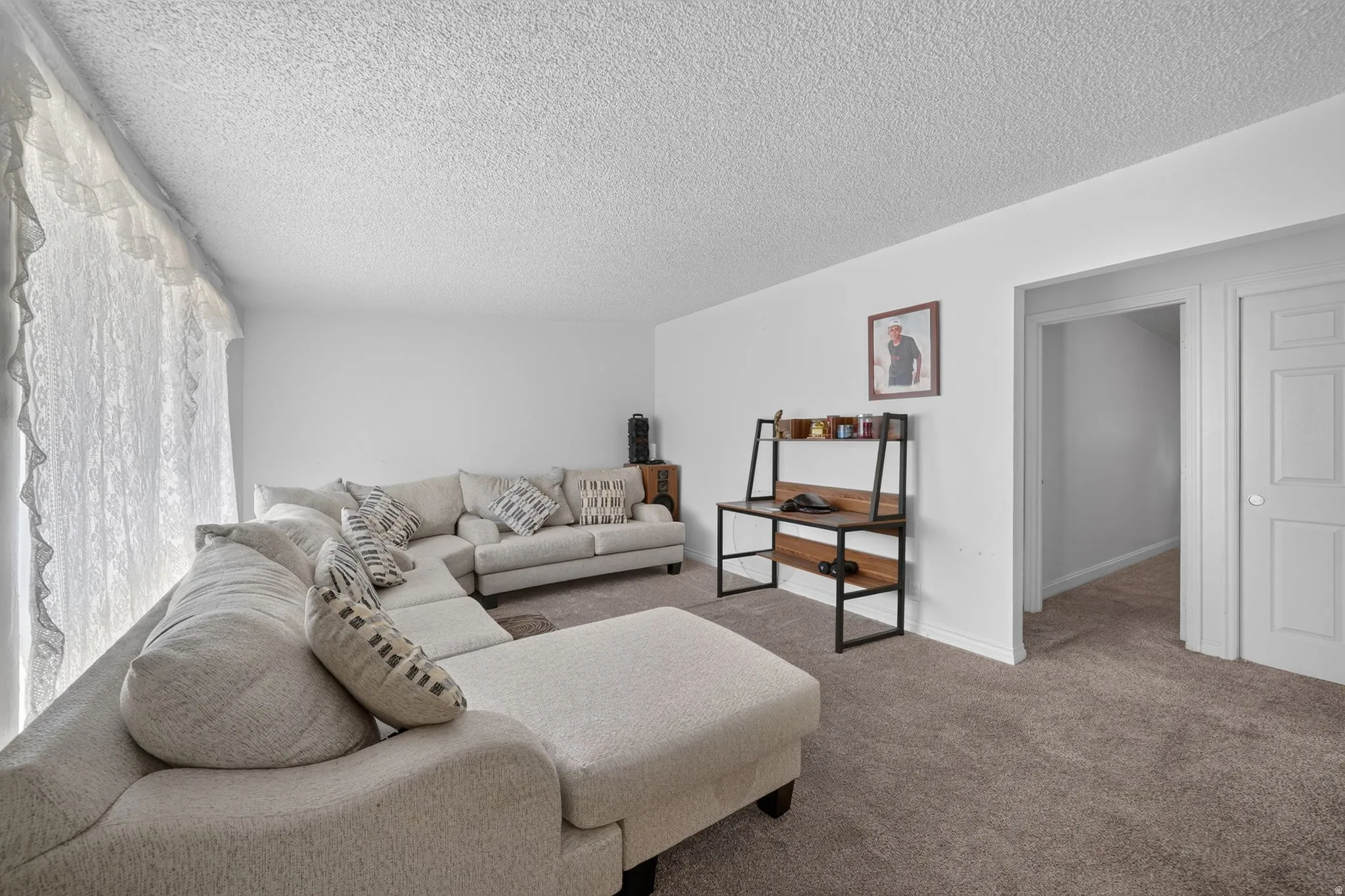 Spacious room featuring neutral carpet flooring and white walls