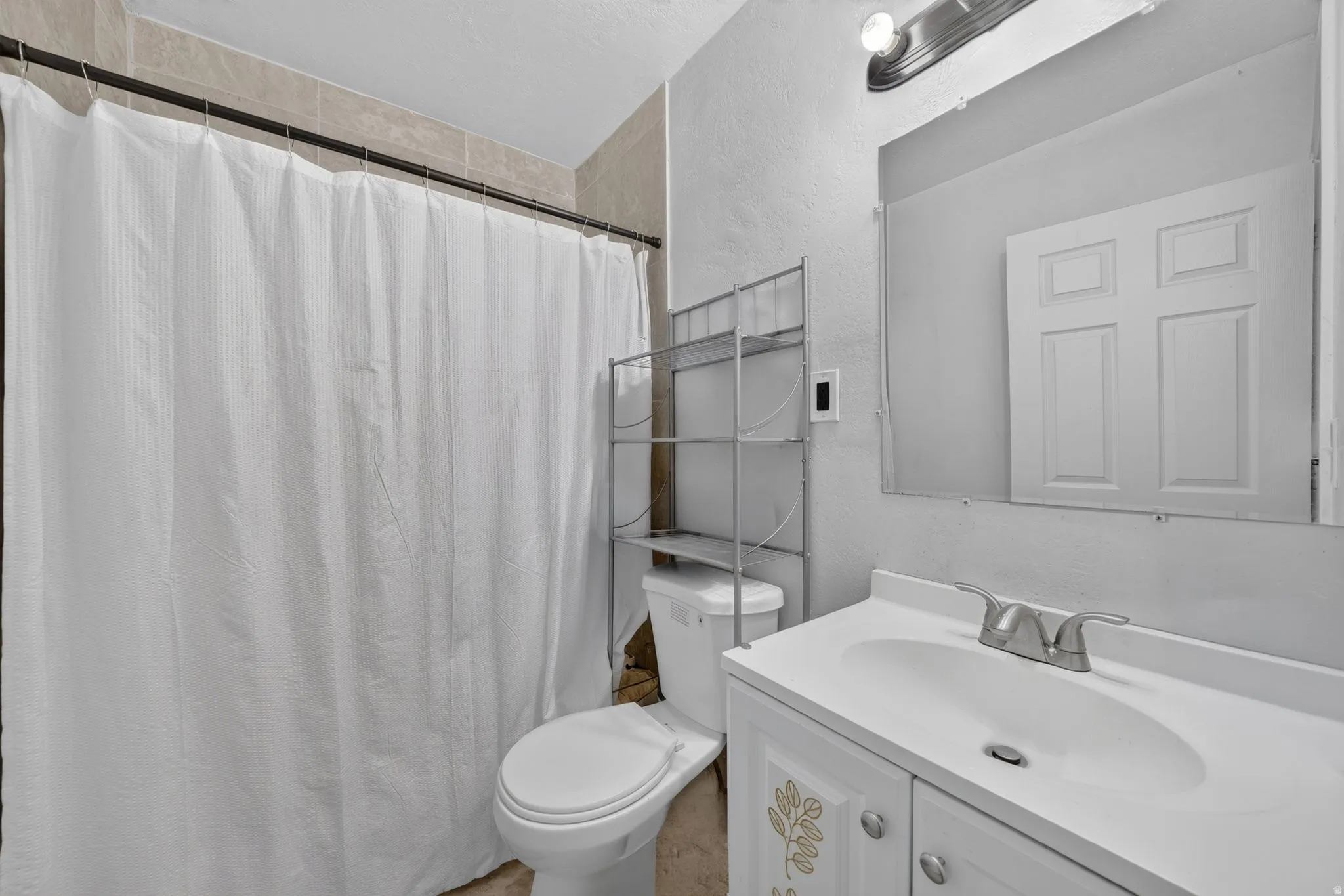 Bathroom featuring a white vanity with an integrated sink, silver-tone faucet, and an above-vanity mirror