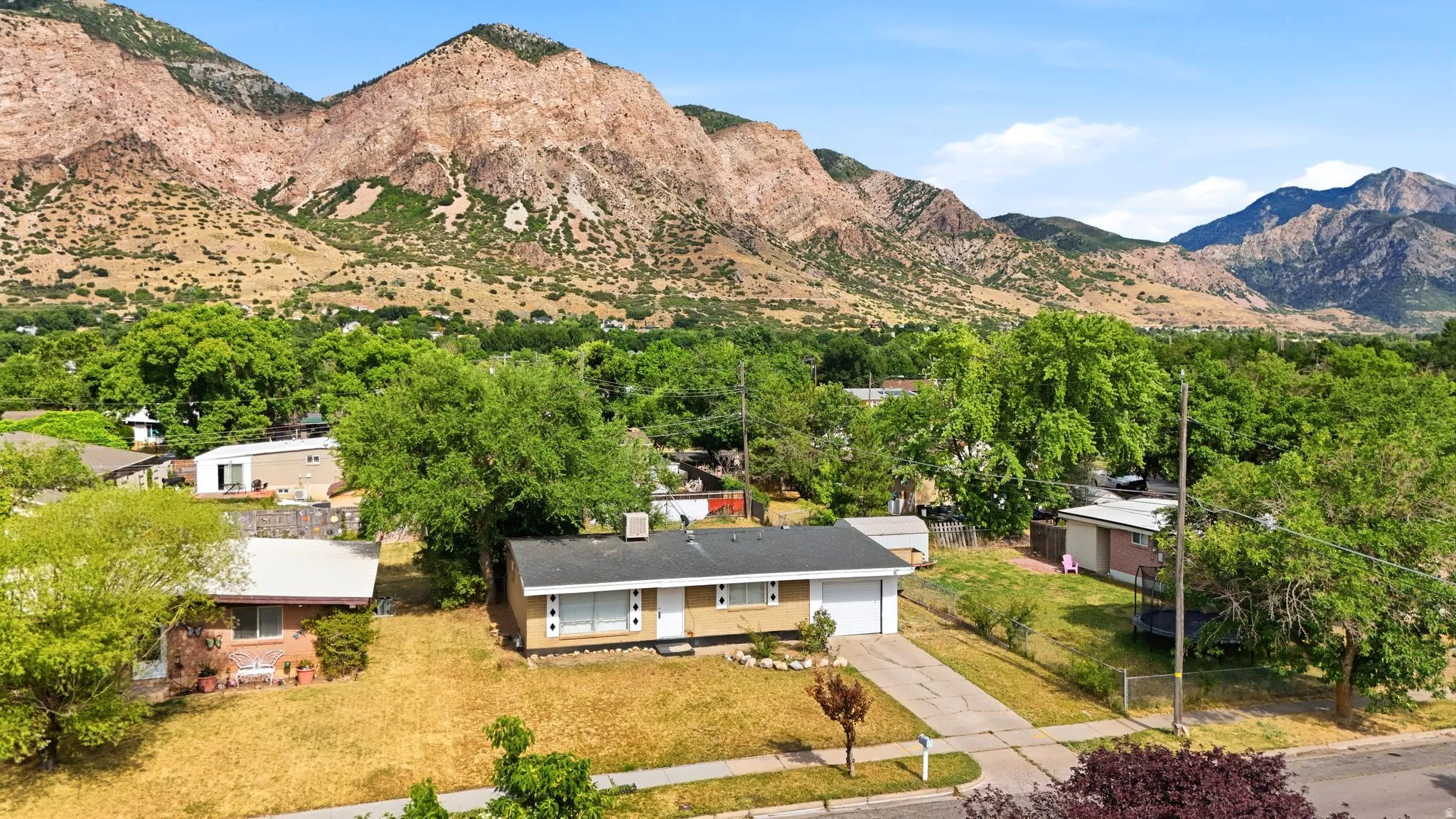 Ranch-style residence featuring a prominent mountain backdrop, attached garage, and a concrete driveway
