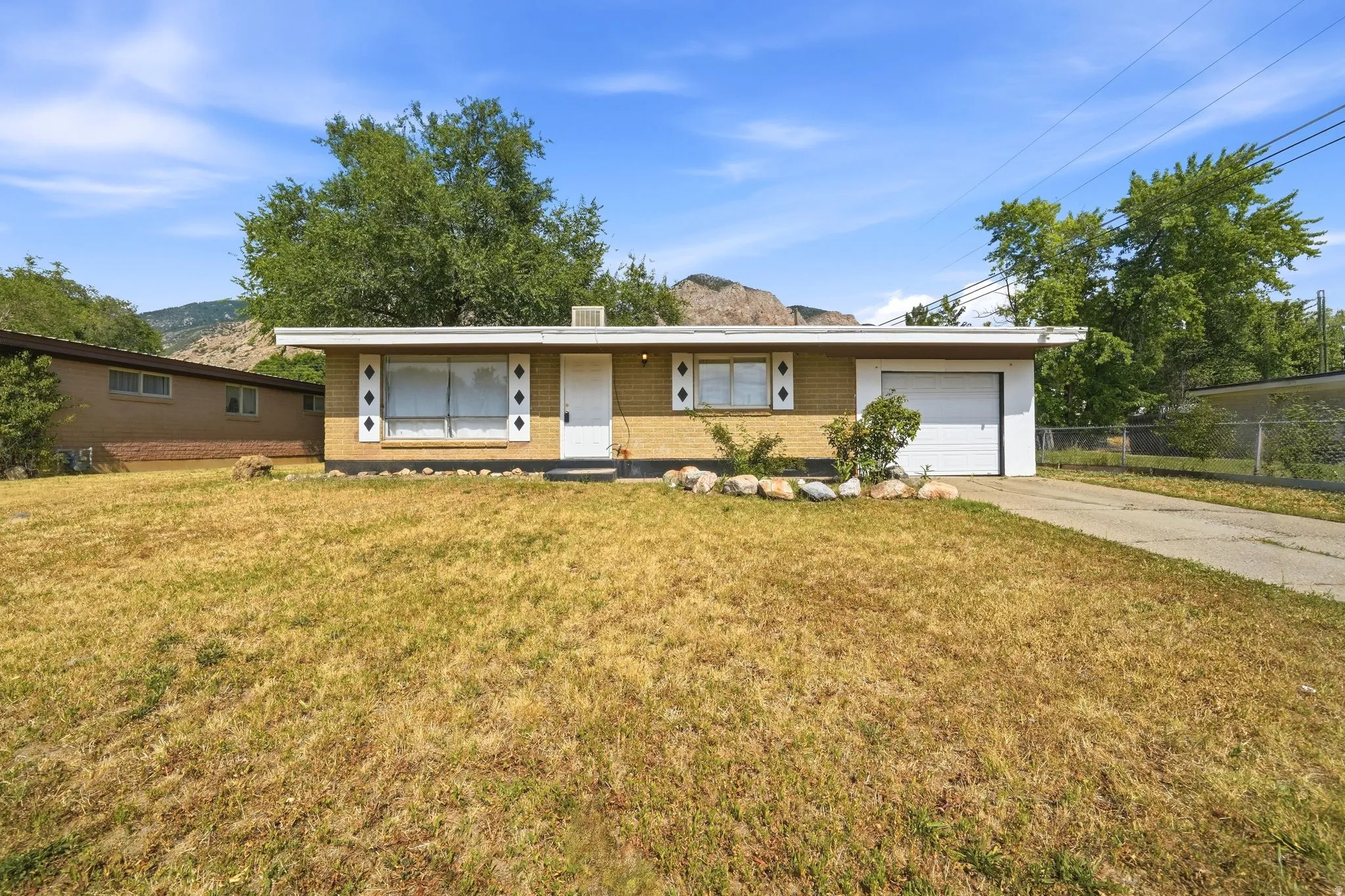 Brick exterior with a flat roofline, integrated garage, and a concrete driveway