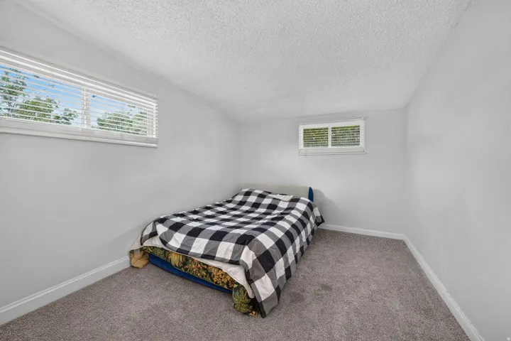 Room featuring light gray walls, gray carpeting, and white baseboards