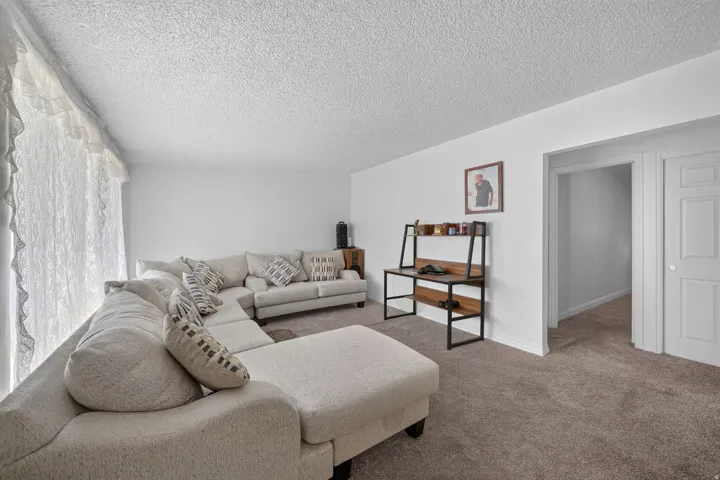 Spacious room featuring neutral carpet flooring and white walls