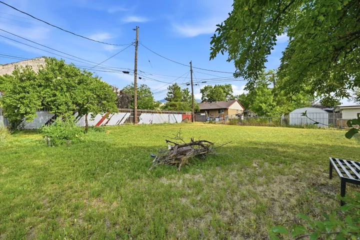 Expansive grassy backyard featuring mature trees